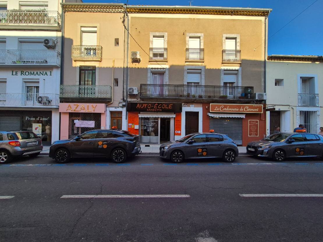 Devanture de l'Auto-école Gambetta à Clermont-l'Hérault avec véhicules de l'école